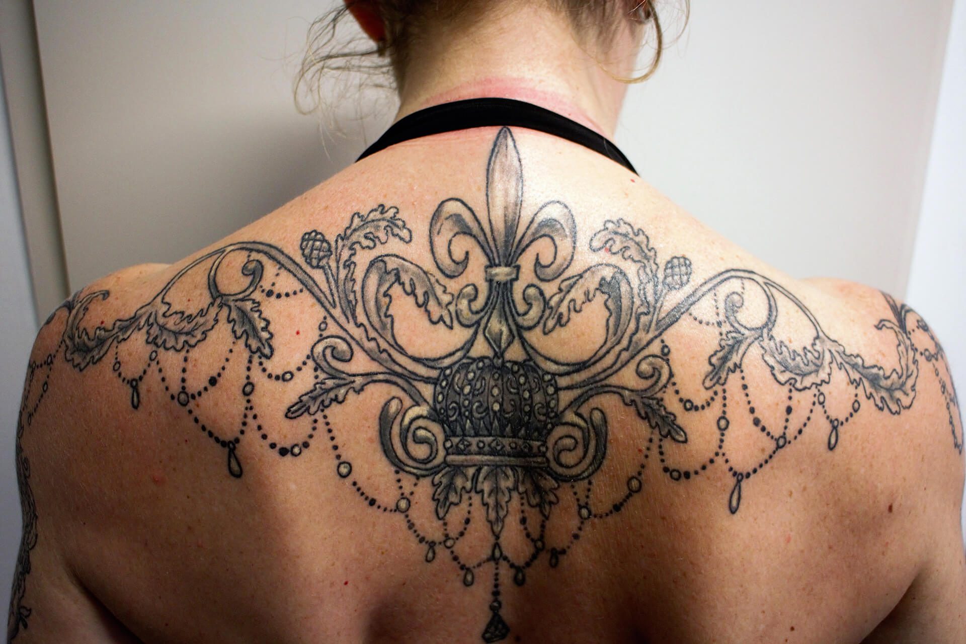 Cosmopolitan Tattoo - Création tatouage baroque, dos féminin, noir et blanc, fleur de lys et entrelas